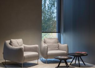 Armchairs by a window with an automated roller shade and motorized shades in Saddle River