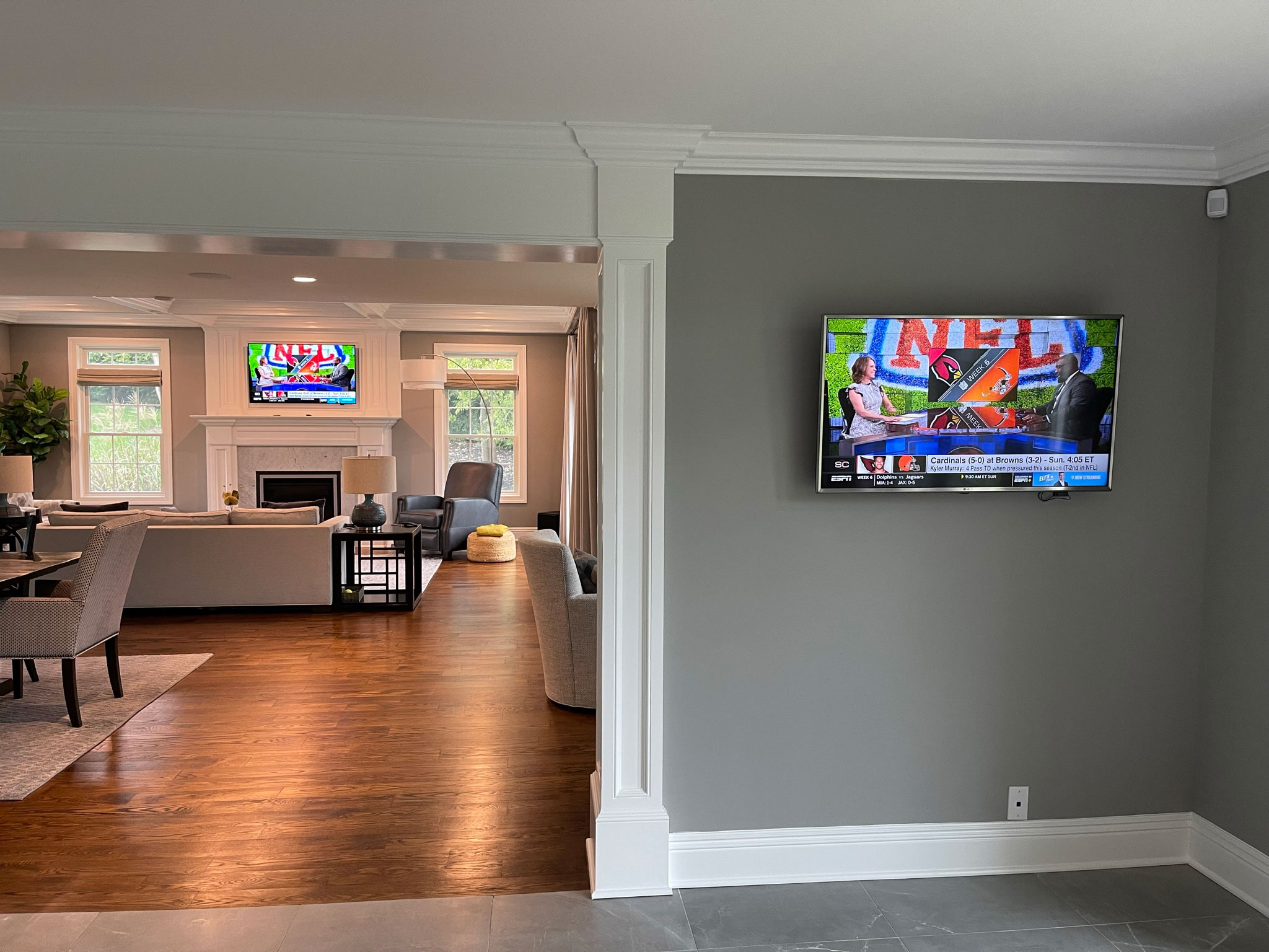 Adjoining rooms with wall-mounted TVs for a home audio and video installation in Chatham