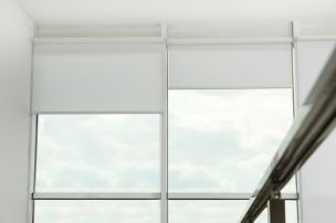 Tall windows with automated shades and motorized shades partially lowered in Ridgewood