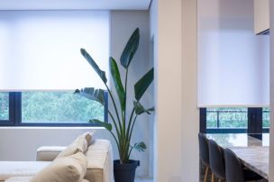 Living area with smart home blinds and automated shades on large windows in Edgewater