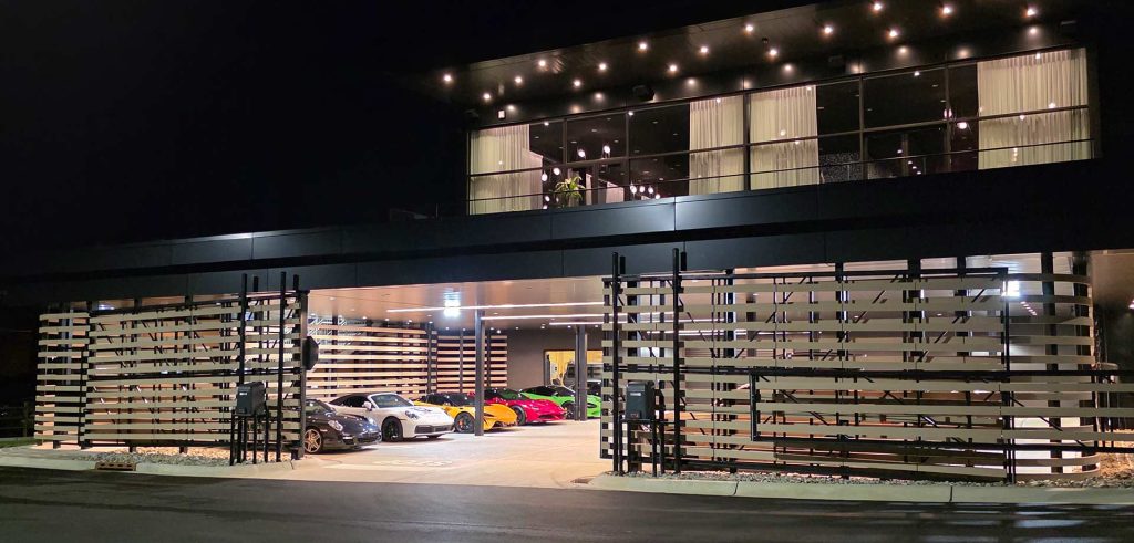 Luxury car club building lit up at night with a commercial A/V installation in Ocean Township