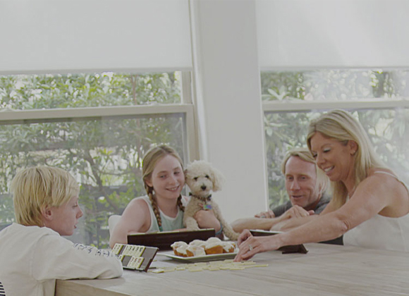 Family relaxing by windows with automatic shades and smart home blinds in Allendale
