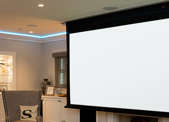 Motorized projection screen lowering in a living room for a home theater installation in Demarest