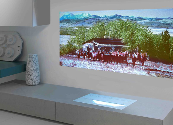 Widescreen projected image above a console with in-wall speakers for a home video wall in New City