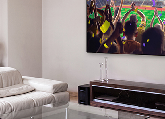 Living room with a large wall-mounted TV and whole home audio in Franklin Lakes