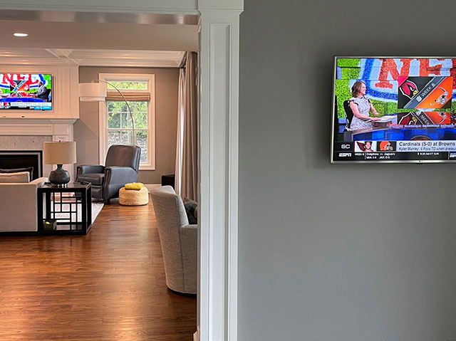 Adjoining rooms with wall-mounted TVs for a home audio and video installation in Montclair