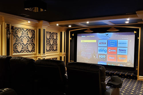 Ornate home theater with a large screen showing streaming apps for a home theater installation in Short Hills