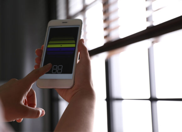 Controlling smart home blinds from a phone app by a window in Midtown Manhattan