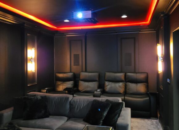 Home theater installation with recliner seating and red cove lighting in Demarest