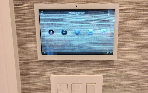 Home automation touchscreen and Lutron lighting keypads in a master bedroom in Saddle River