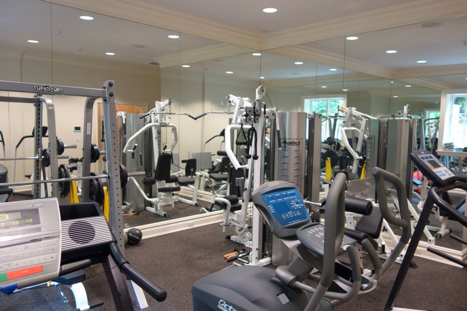 Mirrored home gym with weight machines and cardio equipment in Saddle River