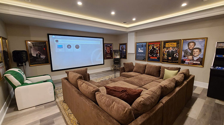 Basement home theater with a projection screen and sectional seating for a home theater installation in Franklin Lakes