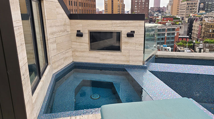 Rooftop plunge pool with an outdoor TV overlooking the city skyline in Tribeca