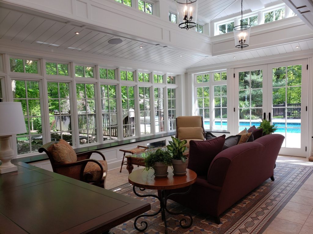 Sunroom with smart home lighting and whole home audio overlooking a pool in Ridgewood