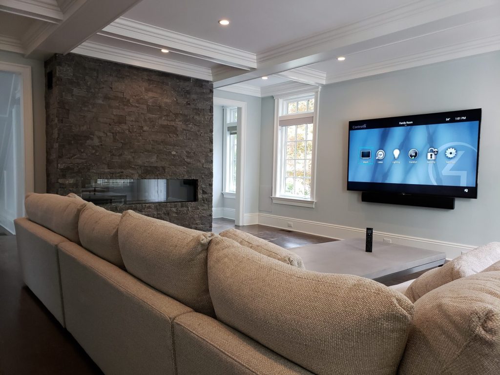 Family room with a Control4 Systems home automation display and a wall-mounted TV in Demarest