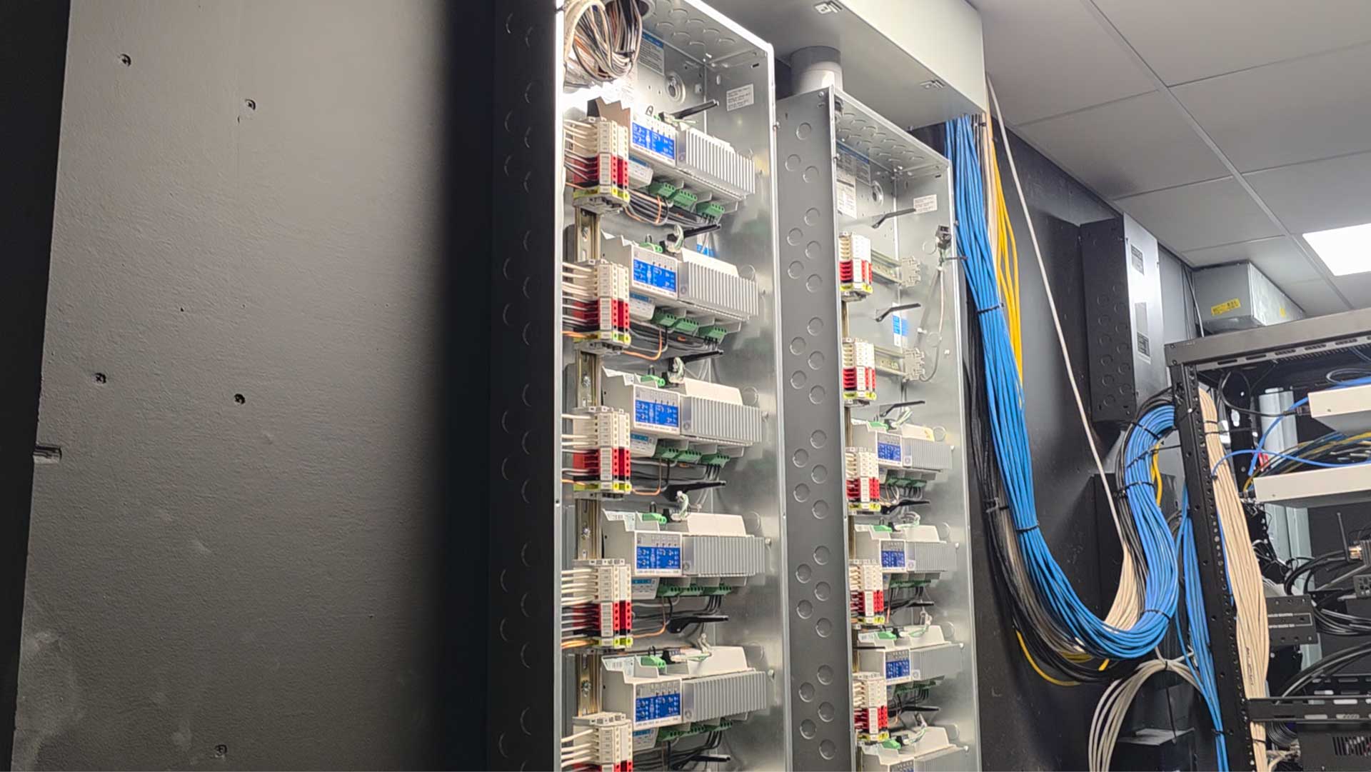 Lutron lighting controls and structured wiring panel in a home automation equipment room in Rumson