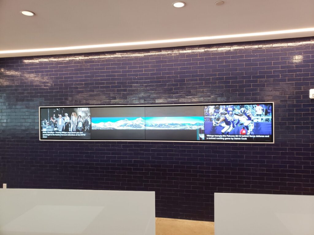 Commercial video wall on a brick wall displaying news and sports in Short Hills